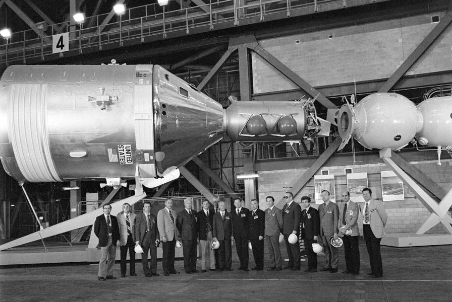 Apollo-Soyuz Test Project (ASTP) mockup in the Vehicle Assembly
	Building (VAB) with Soviet and American ASTP officials (NASA photo
	KSC-S75-24026