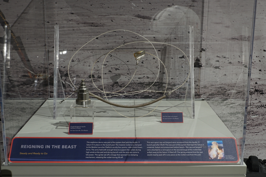 The Saturn V S-II (second) stage port seal and lanyard and Saturn V holddown arm single bridgewire Apollo Standard initiator in the Apollo:  When We Went to the Moon exhibit