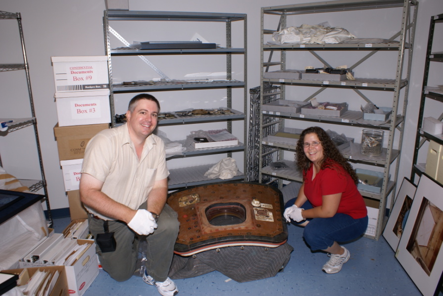 Mike and Jenny Jetzer with the Apollo 13 hatch in the Cosmosphere Vault at the Kansas Cosmosphere