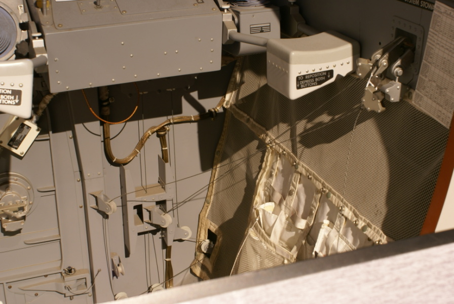 Lunar Module (LM) restraint system, including pulleys and cables.  Hand controller armrest is also visible.  In the LM Cockpit Mockup at the Cradle of Aviation