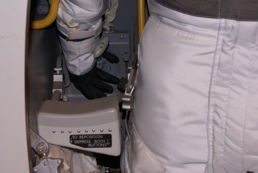 Lunar Module (LM) restraint system, including cables and PGA waist restraint rings. Hand controller armrest is also visible. In the LM Cockpit Mockup at the Cradle of Aviation.