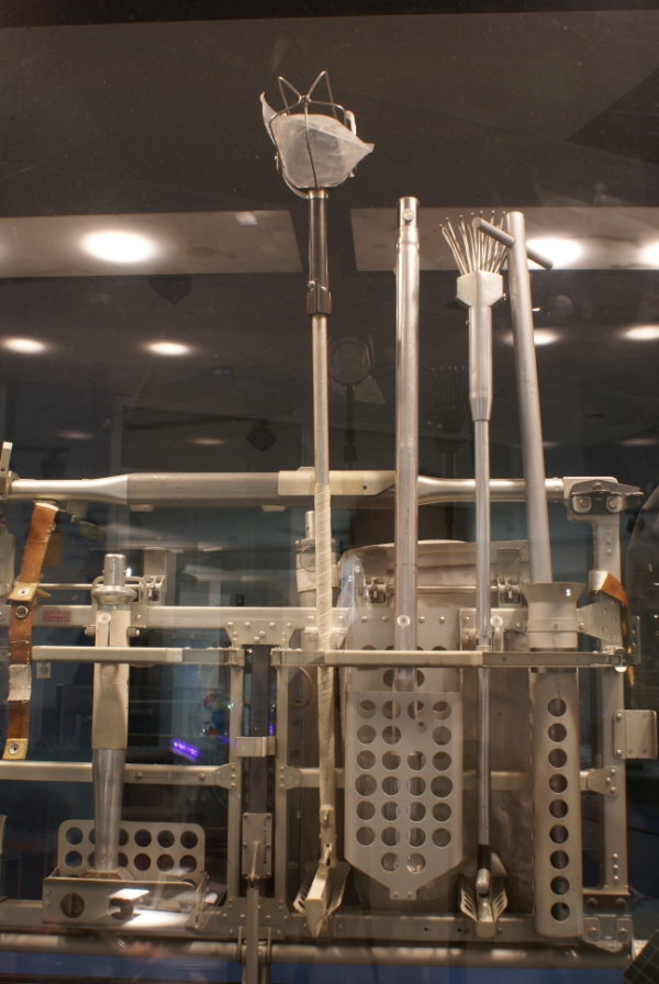 Hammer, soil sampler, adjustable scoop, tongs, and extension handle in the Lunar Hand Tool Carrier at Houston Museum of Natural Science