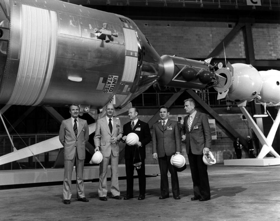 Apollo-Soyuz Test Project (ASTP) mockup in the Vehicle Assembly
	Building (VAB) with astronaut and cosmonaut crews (NASA photo
	KSC-75P-0037