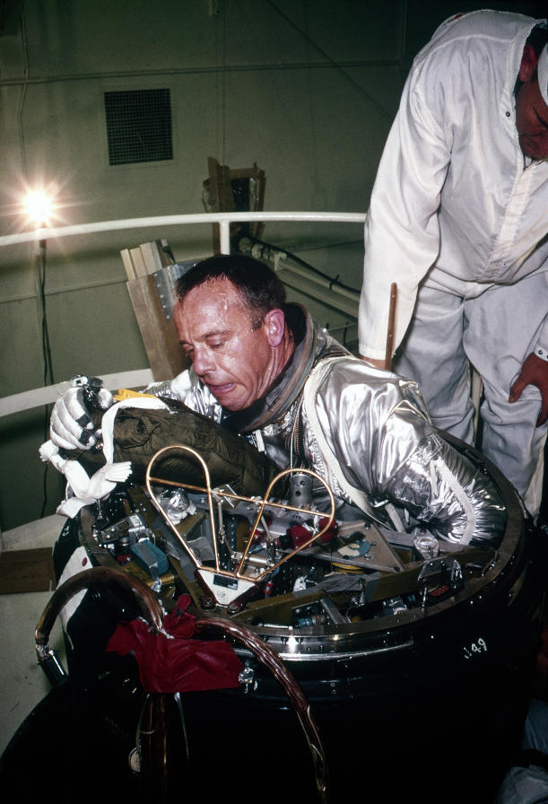 Astronaut Alan Shepard climbing out egressing from Mercury spacecraft forward emergency escape hatch