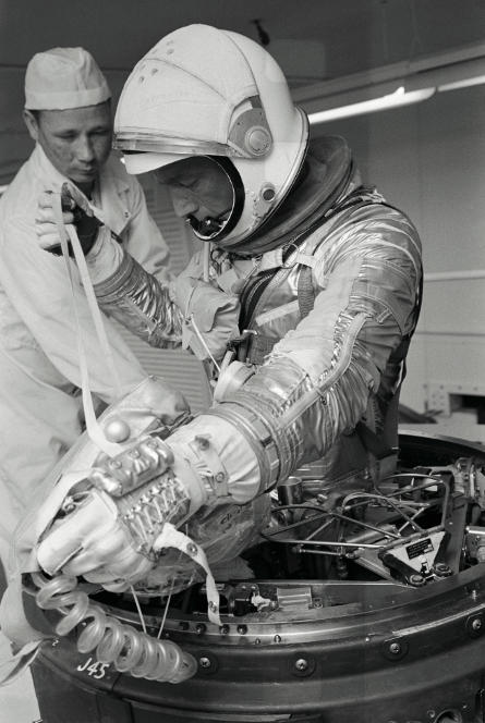 Astronaut M. Scott Carpenter climbing out egressing from Mercury spacecraft forward emergency escape hatch
