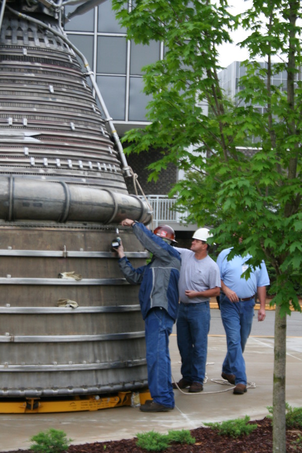 Bolting nozzle extension to F-1 rocket engine thrust chamber during Installation of Building 4200 Engines (May 13, 2008) at Marshall Space Flight Center Engine Displays