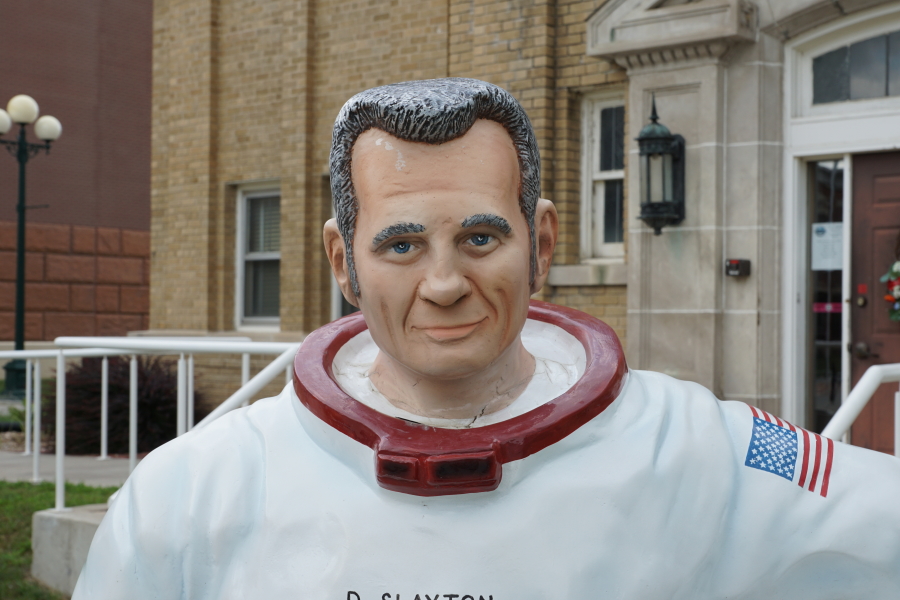 Deke Slayton astronaut in a spacesuit statue in front of Deke Slayton Memorial Space and Bike Museum